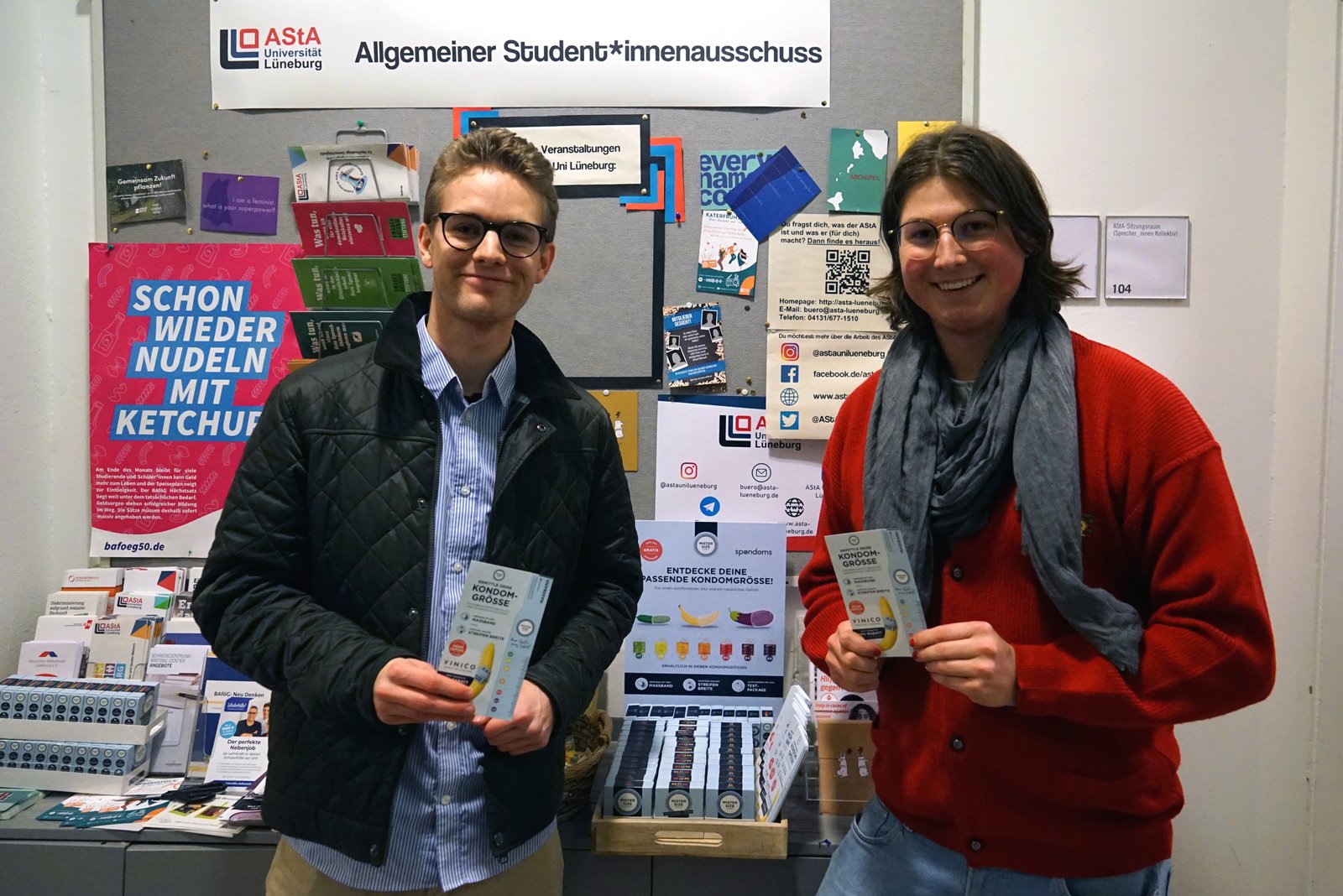 Luis from Spondoms (left) opens the free condom dispenser together with Max from the AStA of Leuphana University Lüneburg (right).